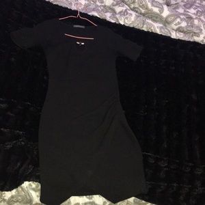 Tight black dress with a leg slit.